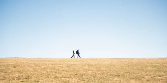 Deux randonneurs au col des Supeyres sous un ciel bleu dégagé.
