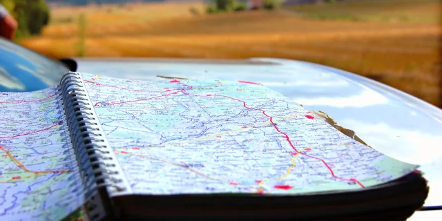 Map on car mask, on second plan summer holidays scenery