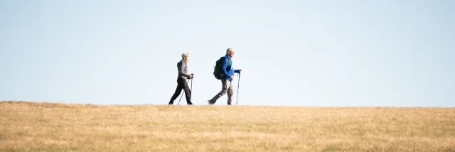 Deux randonneurs au col des Supeyres sous un ciel bleu dégagé