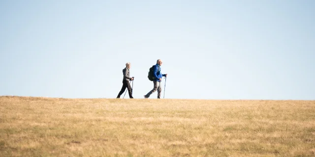 Deux randonneurs au col des Supeyres sous un ciel bleu dégagé
