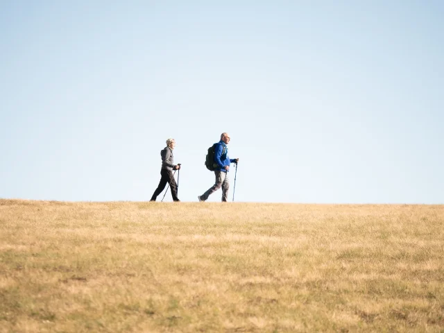 Deux randonneurs au col des Supeyres sous un ciel bleu dégagé