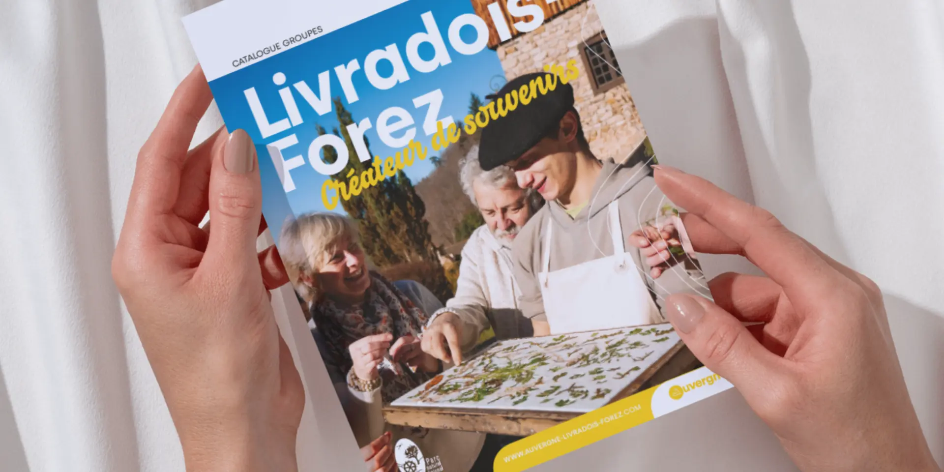 Personne feuilletant le catalogue groupe de la Maison du Tourisme du Livradois-Forez