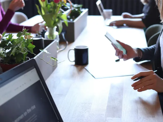 femme travaillant sur un bureau, téléphone à la main