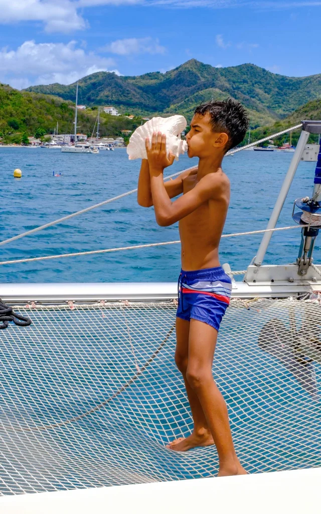 Souffler dans une conque de lambis Catamaran Kokoumdo Trois-Ilets Martinique