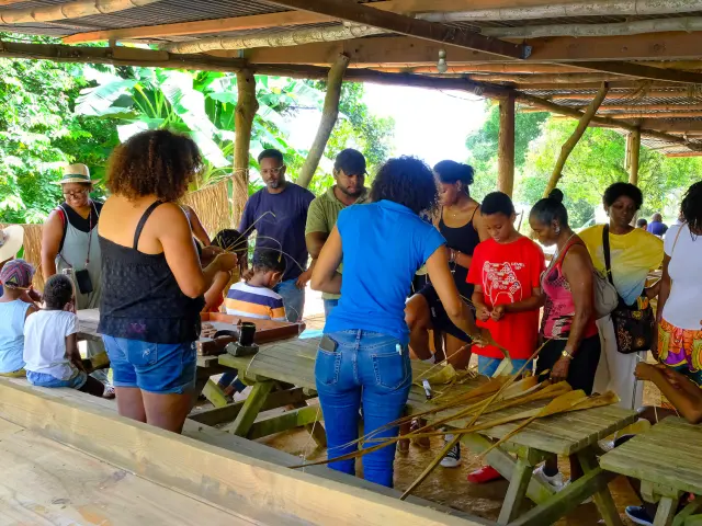 Participant(e) s’initiant au tressage de bakoua dans un atelier de Lakoua.