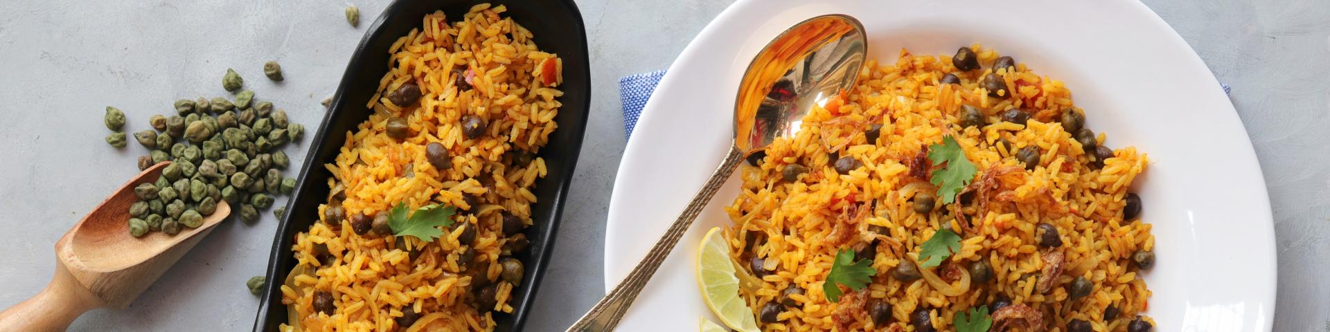 Indian cuisine - Chickpeas Biryani, chole Pulao. Garnished with fried onion, chopped coriander, and lemon wedges. Kala chana biryani. Along with copy space.