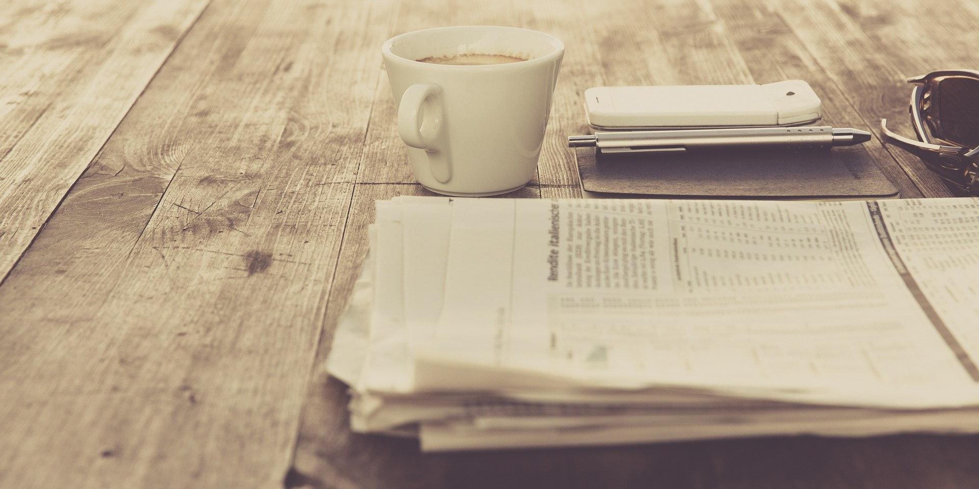 Journal et tasse à café sur une table
