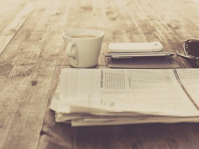Journal et tasse à café sur une table