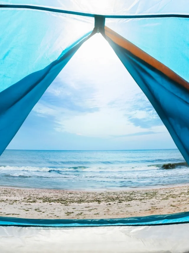 Photo of a sunny day sea shore view from a blue camping tent door.