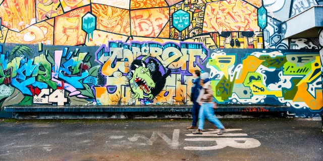 Couple se baladant devant une fresque Street art à Saint-Julien-en-Genevois