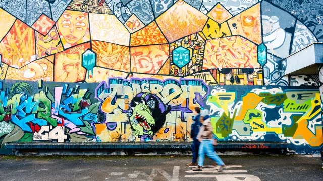 Couple se baladant devant une fresque Street art à Saint-Julien-en-Genevois