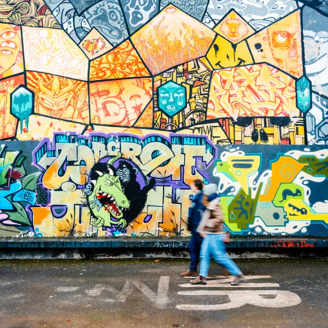 Couple se baladant devant une fresque Street art à Saint-Julien-en-Genevois