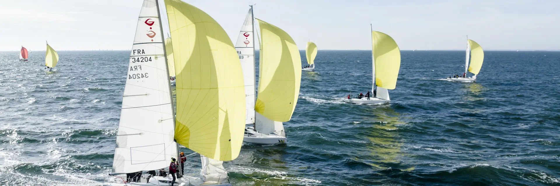 Régate de voiliers de course identiques naviguant par mer formée