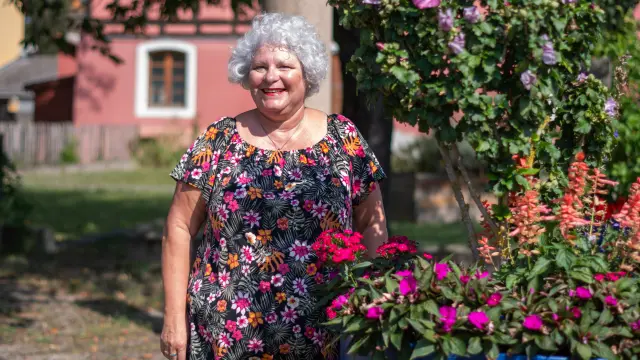 Une dame se tenant debout à côté d'un pot de fleurs
