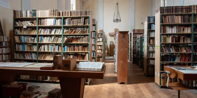 Bibliothèque des moines de l'Abbaye d'Oelenberg - nombreux rayonnages avec des livres et des tables pour les consulter.