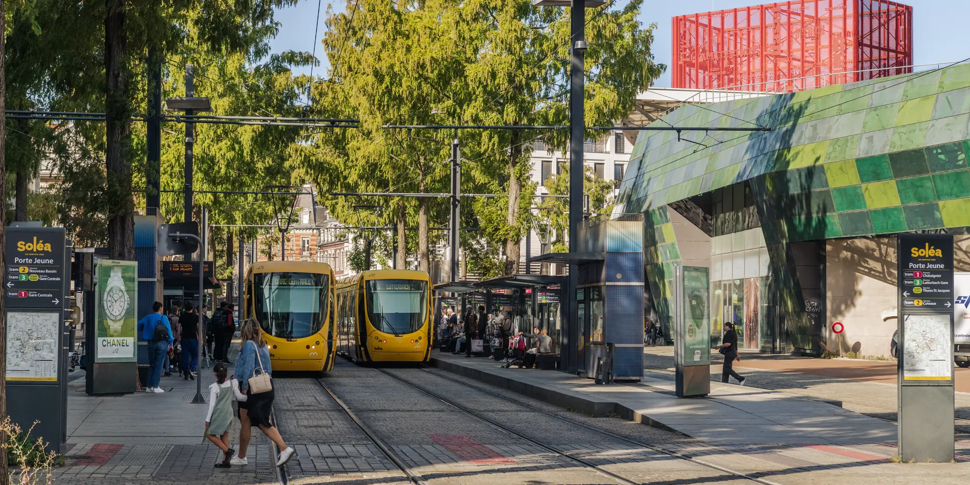 Deux trams jaunes à l'arrêt à la station Porte Jeune à Mulhouse.
