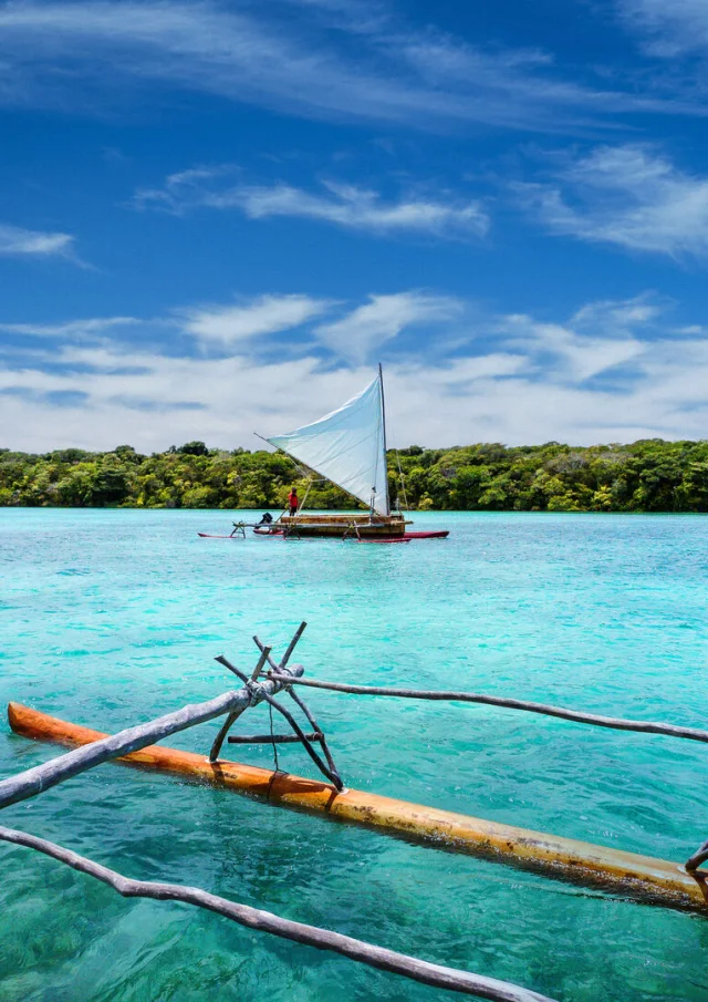 ニューカレドニア、イル・デ・パンのバイ・ドゥピのターコイズブルーのラグーンでの伝統的なピローグでのエクスカーション。