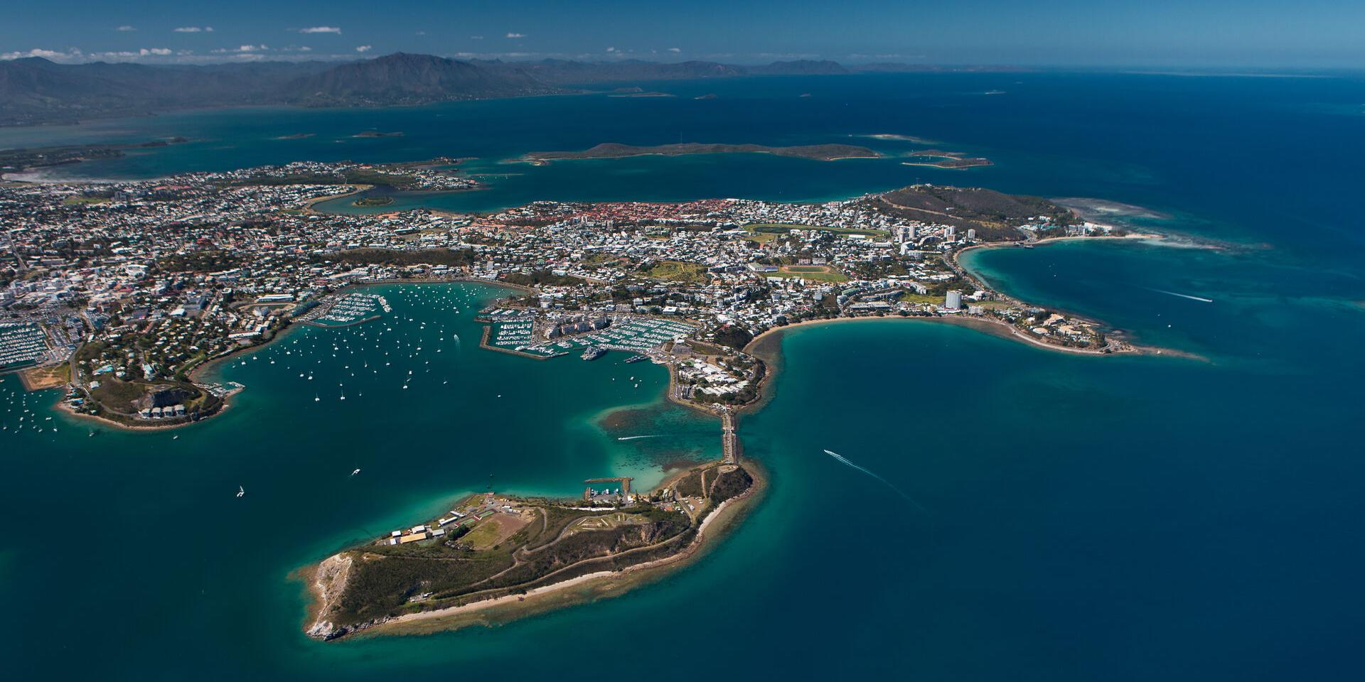 Vue aérienne de l'ensemble de la ville de Nouméa, capitale de la Nouvelle-Calédonie, entouré de ses baies et de son lagon.
