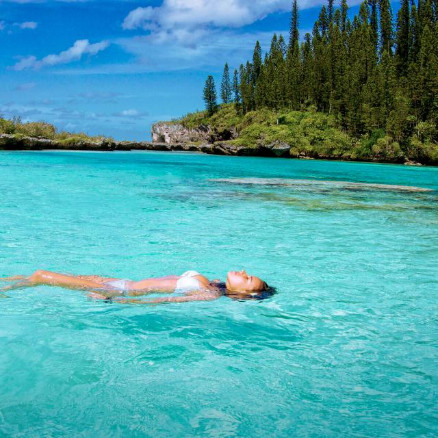 Détente à la Piscine naturelle d'Oro et son eau cristalline, entourée des pins colonnaires à l'Île des Pins, en Nouvelle-Calédonie.