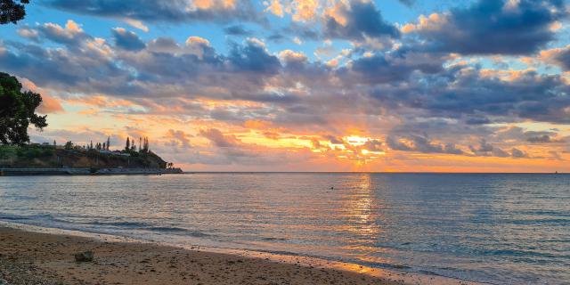 Coucher du soleil sur la plage de la Baie des Citrons à Nouméa, en Nouvelle-Calédonie.