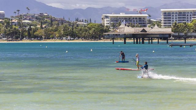 Kitesurf et stand-up paddle sur la plage de l'Anse Vata à Nouméa, en Nouvelle-Calédonie.