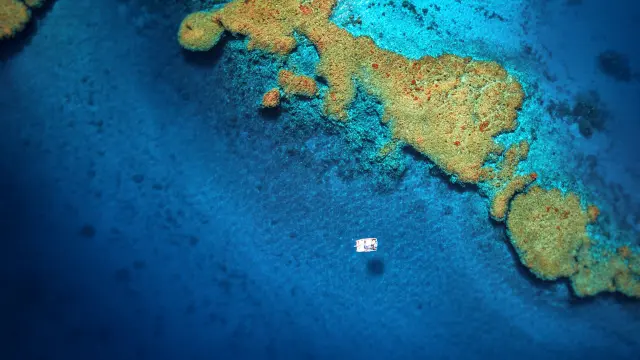 Vue aérienne d’un catamaran sur le lagon bleu, près des récifs coralliens aux alentours de Hienghène, en Nouvelle-Calédonie.