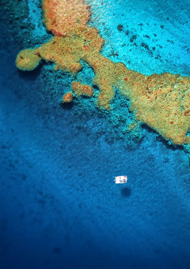 Vue aérienne d’un catamaran sur le lagon bleu, près des récifs coralliens aux alentours de Hienghène, en Nouvelle-Calédonie.