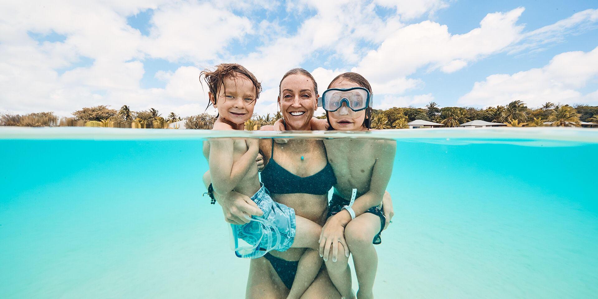 Family swimming in the Ouvéa lagoon