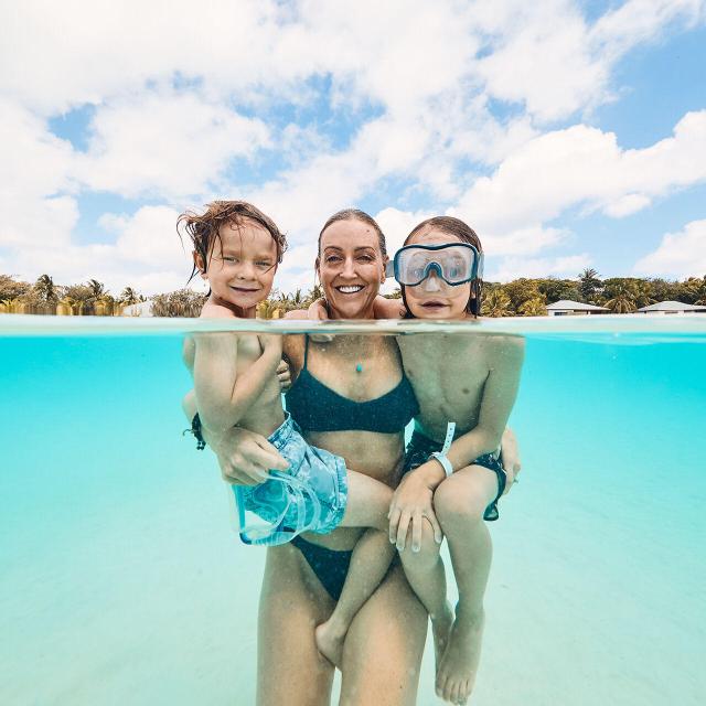 Family swimming in the Ouvéa lagoon