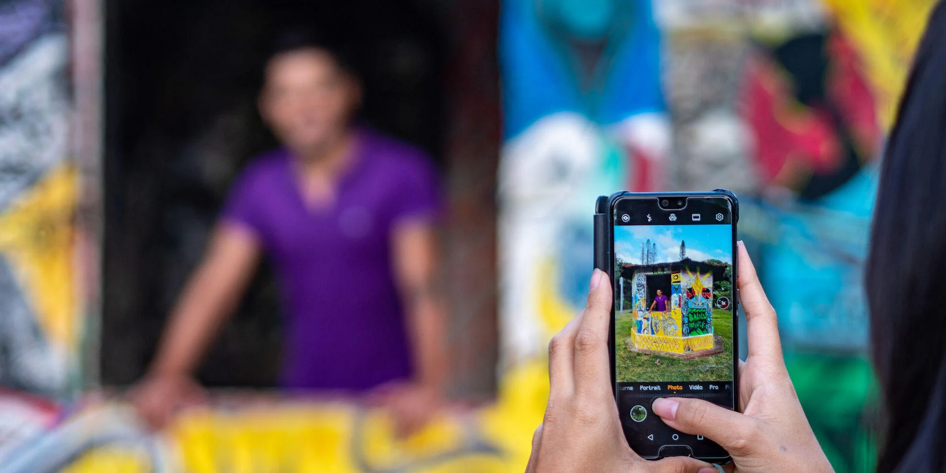 Touristes se prenant en photo avec du Street Art à Thio, Côte Est de la Nouvelle-Calédonie.