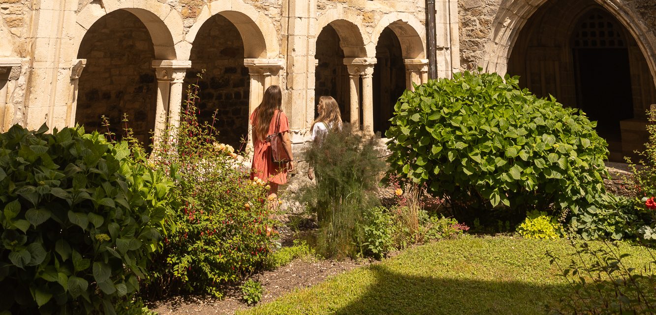 Deux femmes marchent dans la cour du Prieuré dans le cloître de Carennac.