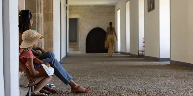 Un enfant et sa mère assis à l’intérieur de l’Abbaye d’Aubazine