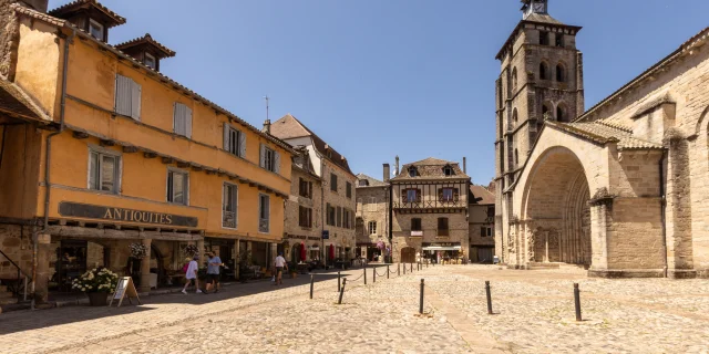 Vue sur la place des Pères : commerces, cafés et l'Abbatiale Saint-Pierre