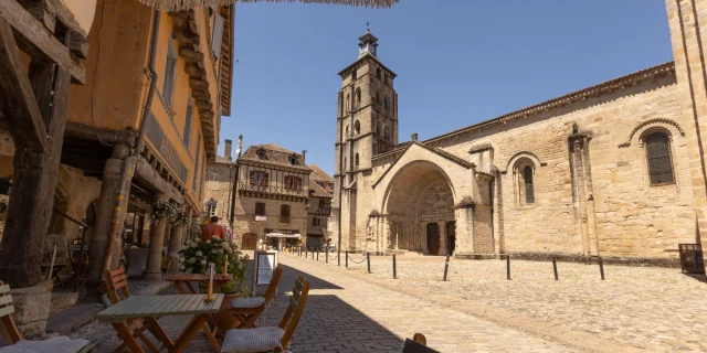 Vue sur la place des Pères : commerces, cafés et l'Abbatiale