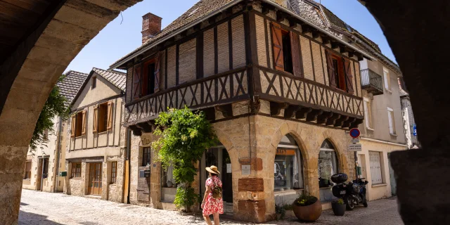 Femme qui marche sur les ruelles à galets dans la bastide de Bretenoux