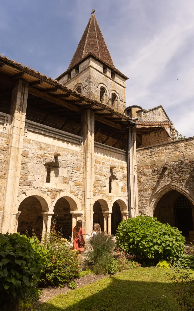 Deux femmes marchent dans la cour du Prieuré dans le cloître de Carennac.