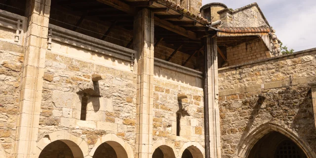 Deux femmes marchent dans la cour du Prieuré dans le cloître de Carennac.