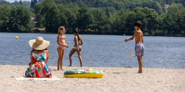 Enfants qui jouent sur la plage du lac de Coiroux à Aubazine