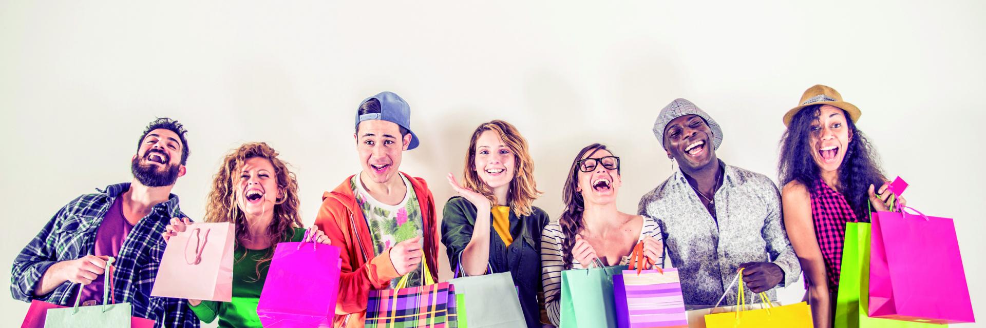 Multi-ethnic group of people holding colored shopping bags and laughing - Portrait of funny friends posing on white background