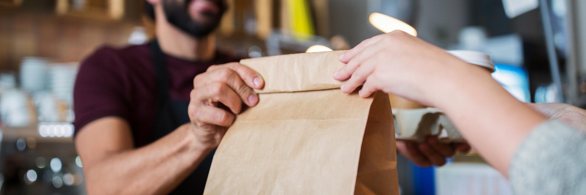 small business, people and service concept - man or bartender serving customer at coffee shop