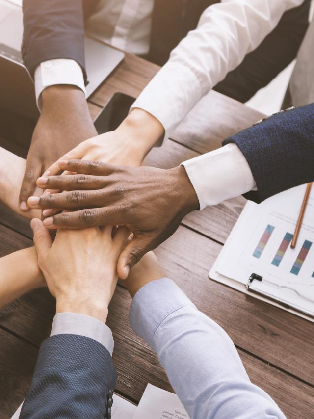 Business collaboration. Top view on diverse corporate team hands stacked together in office, top view