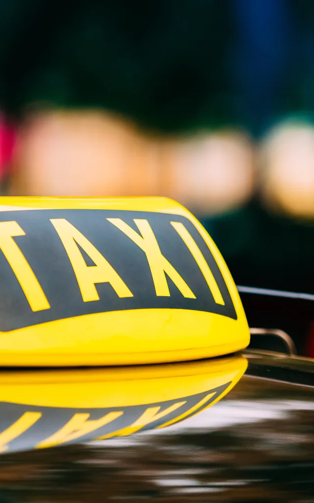 Cartel amarillo de taxi en el techo del coche.