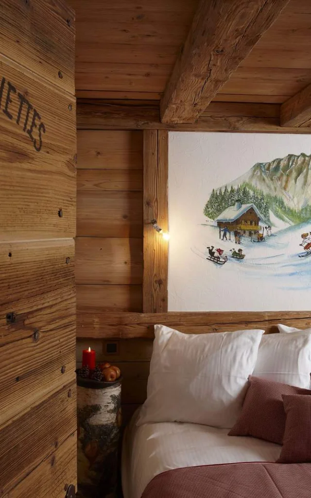 Houten slaapkamer, bed rechts met een schilderij van een skiër erboven