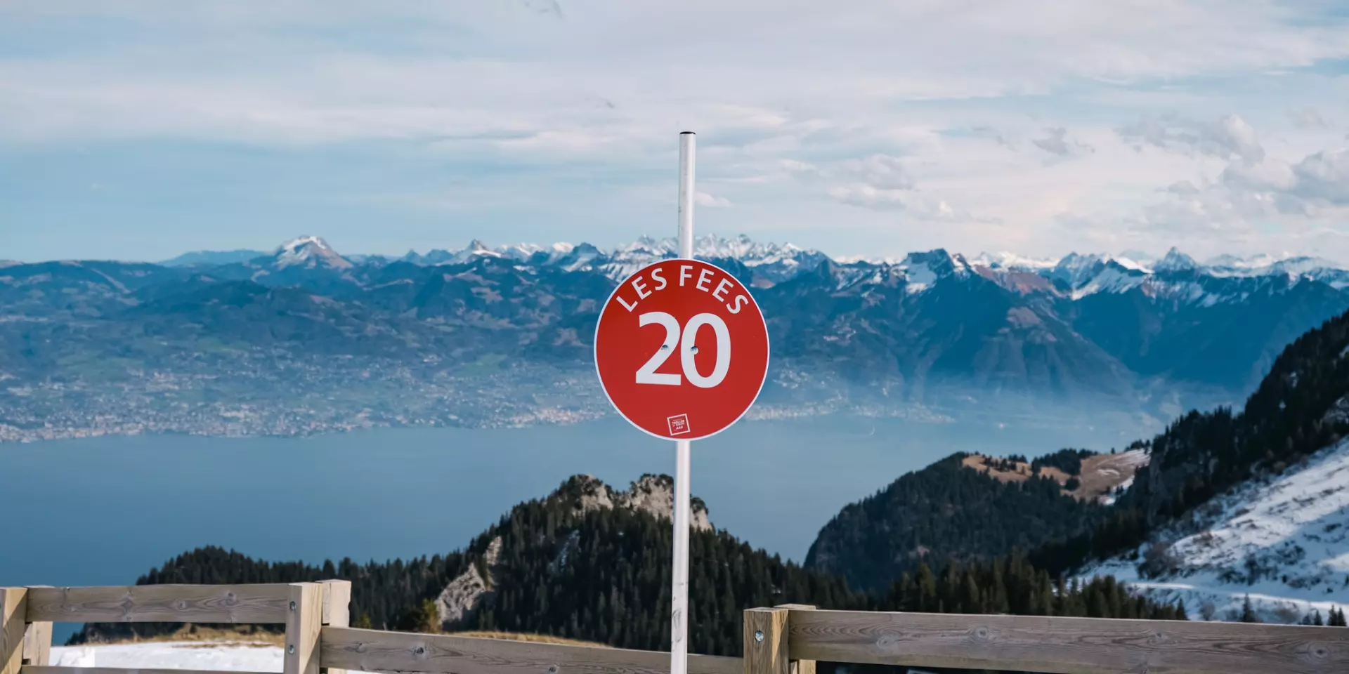 Haut Des Pistes De Ski Thollon Les Memises. On voit au premier plan un panneau indiquant la piste rouge Les Fées. En fond il y a le lac Léman et les montagnes suisses.