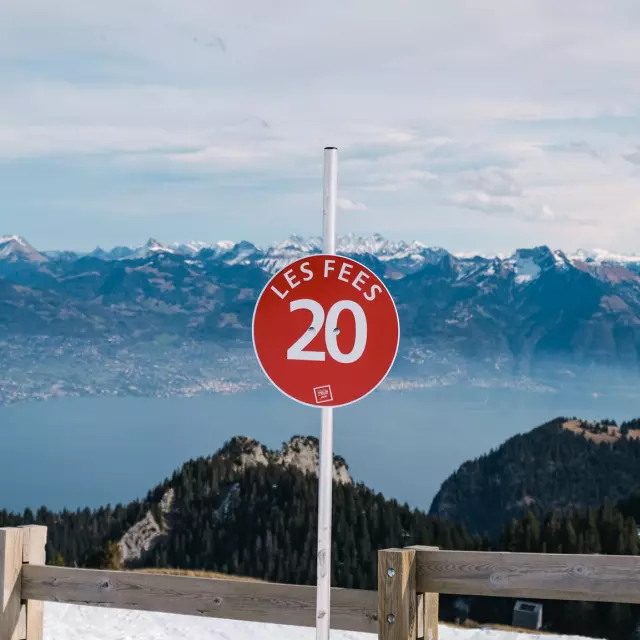 Haut Des Pistes De Ski Thollon Les Memises. In the foreground is a sign for the red 