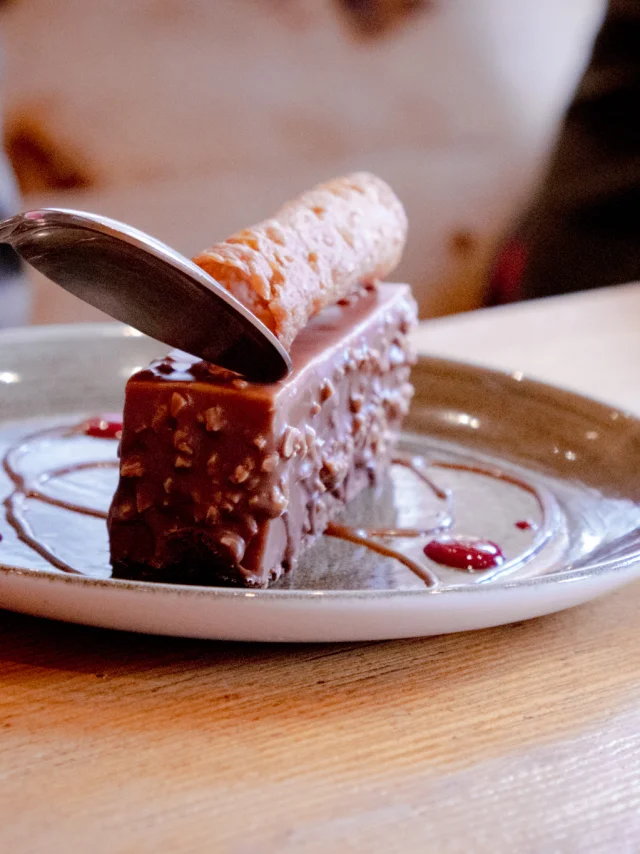 A chocolate entremet on a white plate