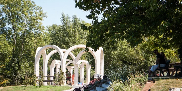 A spring among the trees formed by white arches