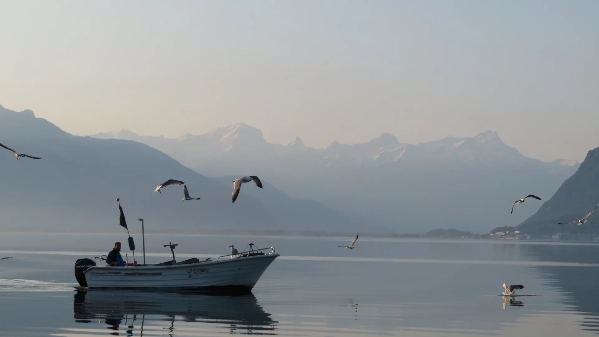 A fishing boat on the lake in the morning.