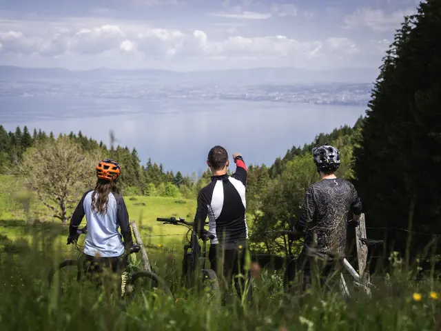 3 personnes à vélo, sur le Plateau de Gavot, avec vue sur le lac