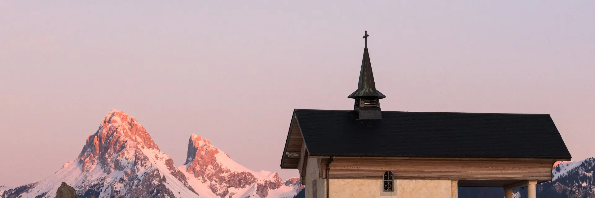 La chapelle de Champeillant en hiver, au coucher de soleil avec la Dent d'Oche enneigée en arrière plan.